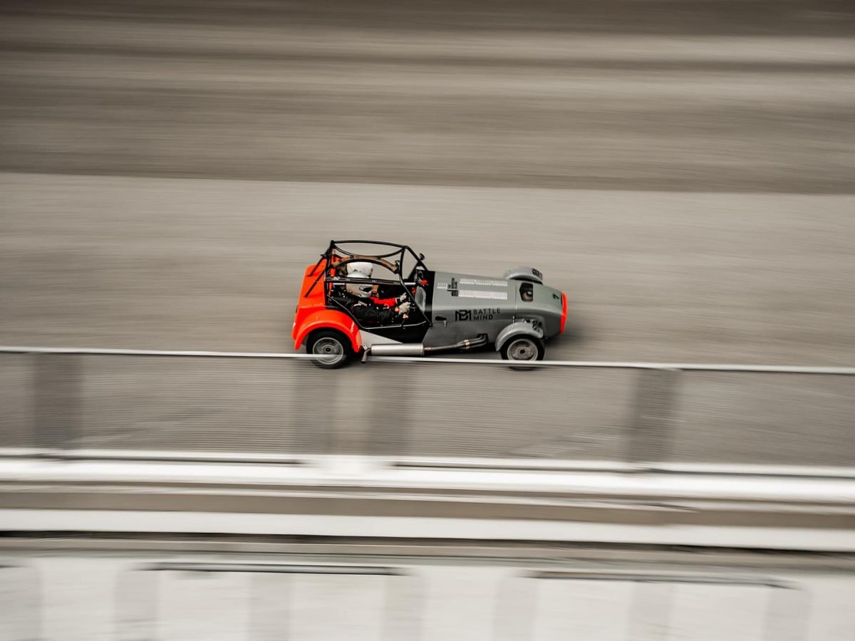 Caterham Seven blurring past on track, shot from above